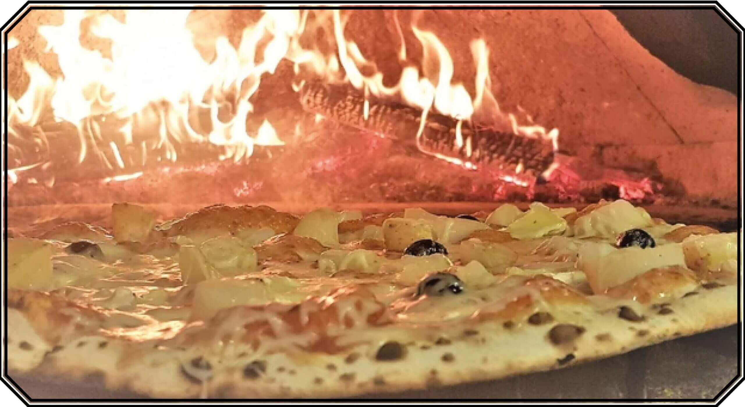 Pizza entrain de cuire dans un four au feu de bois