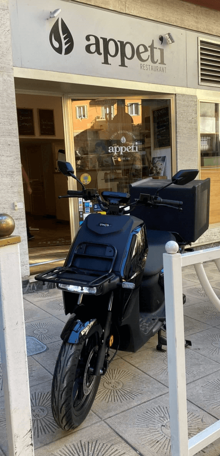 Scooters électrique noir garé devant un restaurant