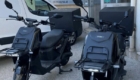 Deux scooters électriques garés devant une pizzeria