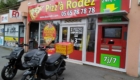 Deux scooters électriques noirs garés devant un restaurant à RODEZ