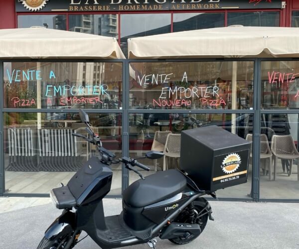 Scooter électrique garé devant un resto